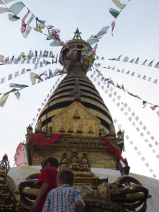 Reaching the top of the eastern staircase with gilded Swayambhunath stupa spire and brass-plated dorje (thunderbolt) symbol (foreground), Swayambhunath
