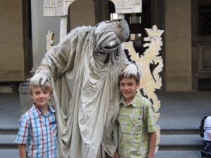 Creepy street performer blessing the children in front of the Uffizi Museum, Florence, Italy